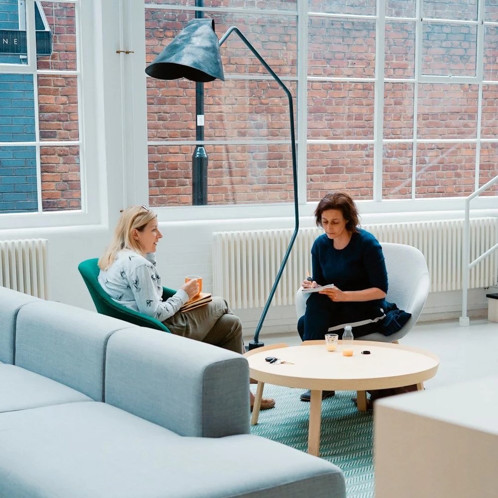 Two coaches in conversation in a bright studio space
